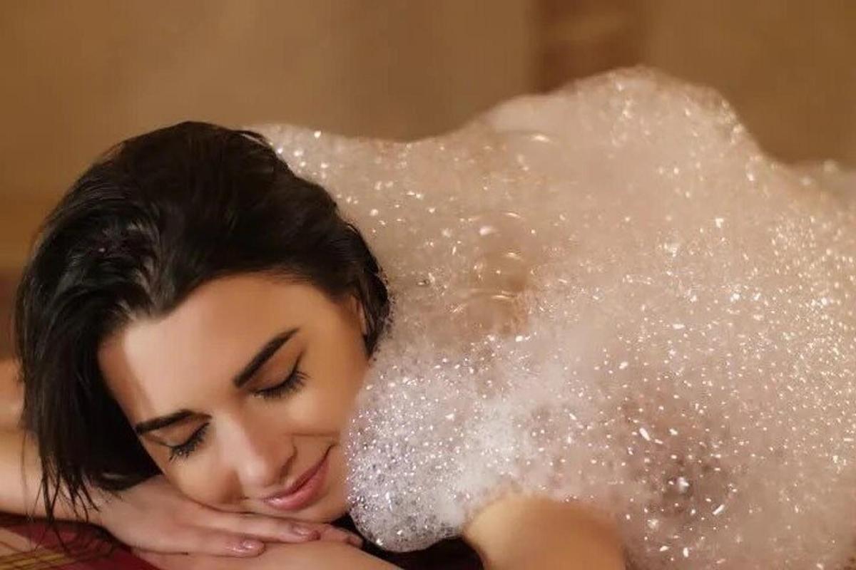 una donna sdraiata su un letto ricoperto di brillantini