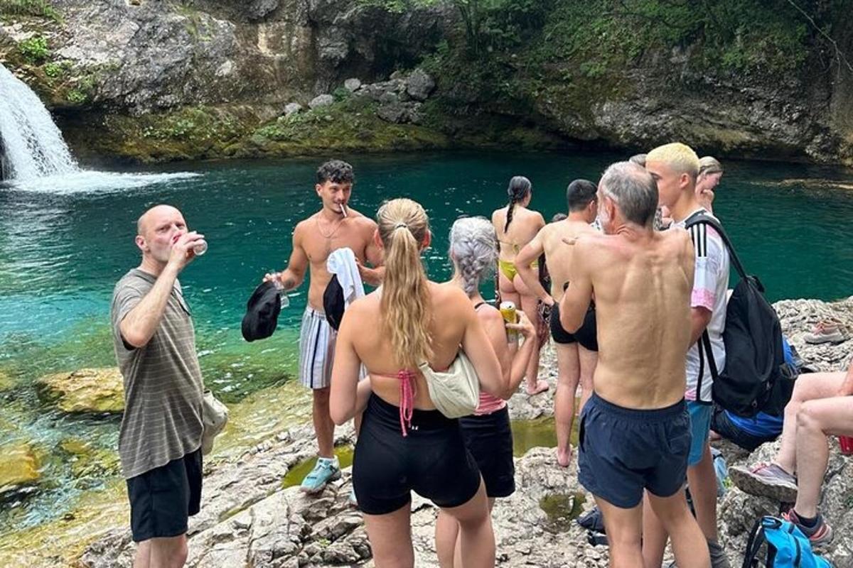 skupina ľudí stojacich na skalách pri vodopáde