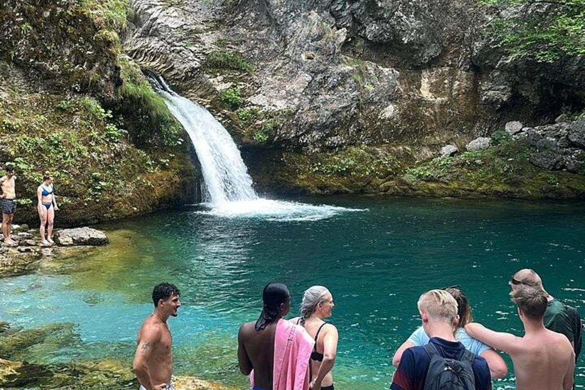 hópur fólks stendur fyrir framan foss