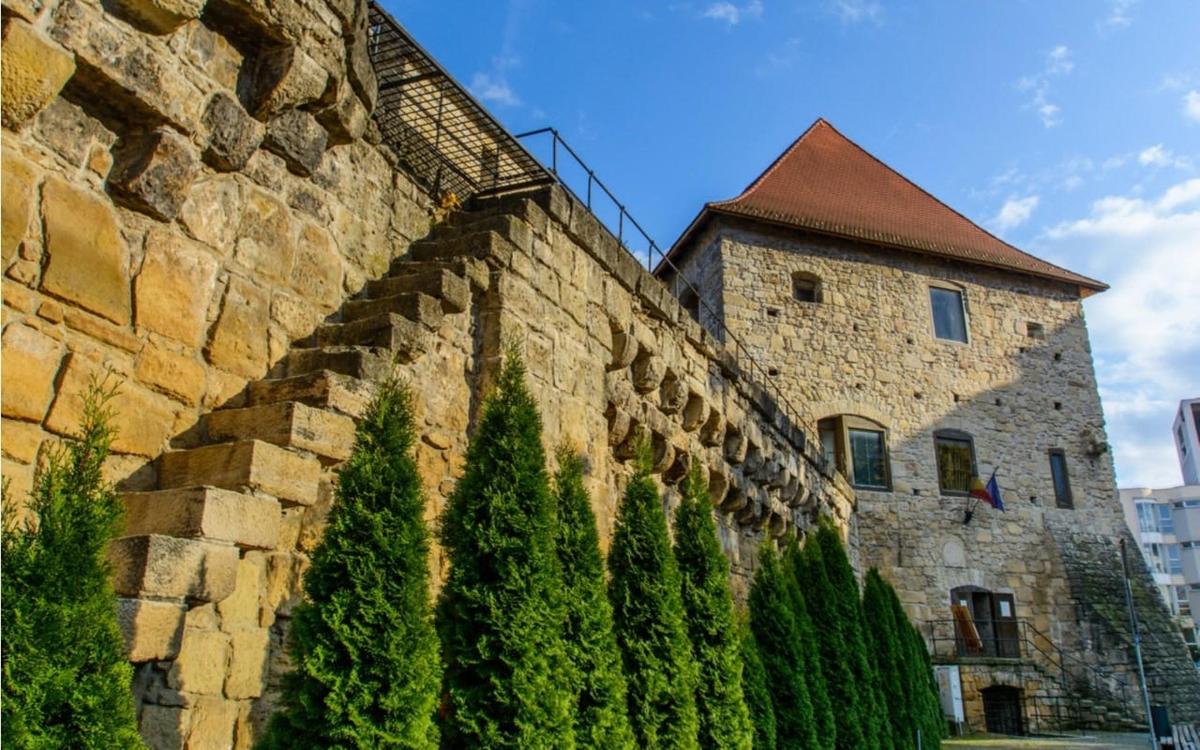 eine Steinmauer mit Bäumen neben einem Gebäude
