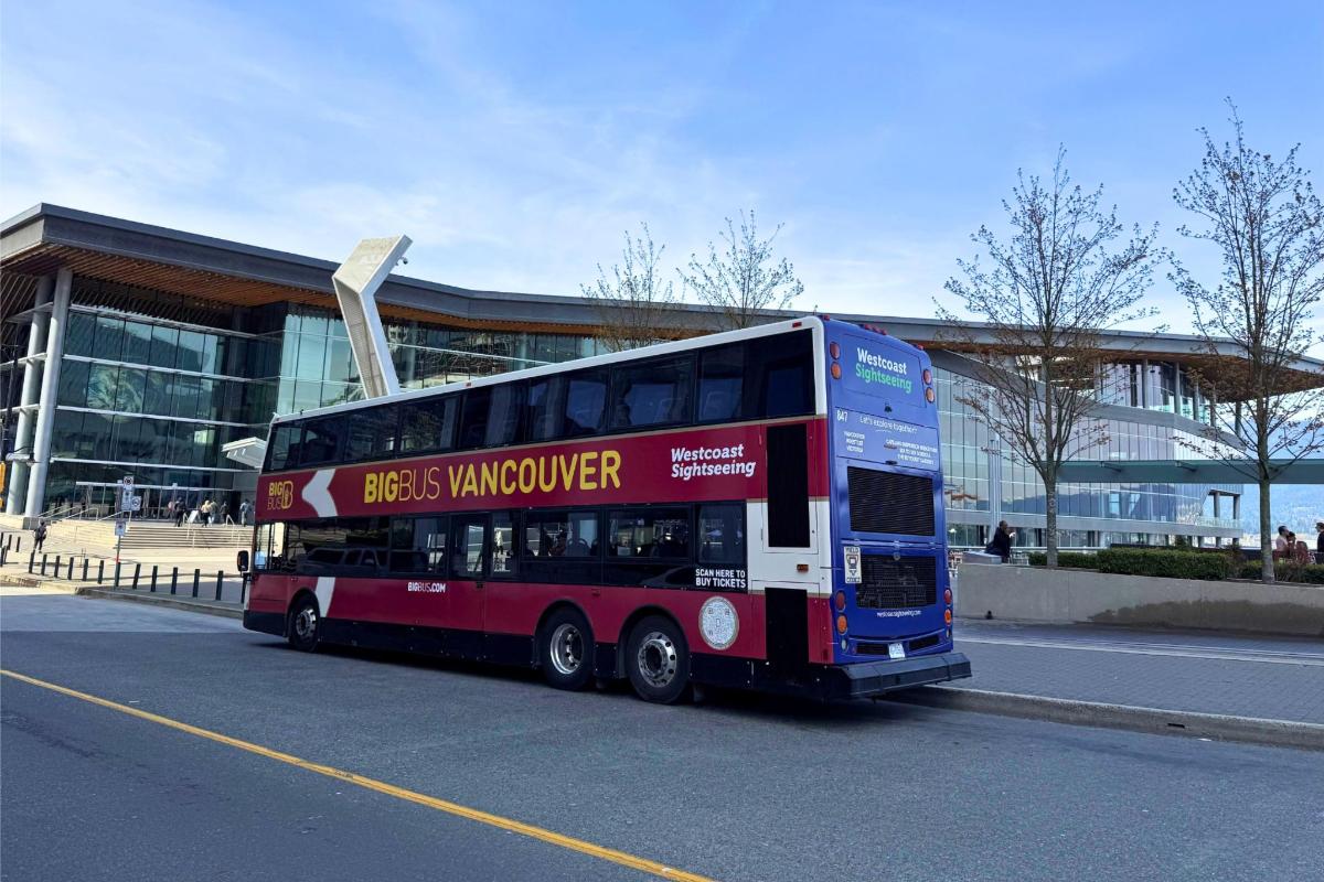 egy emeletes busz parkolt egy épület előtt