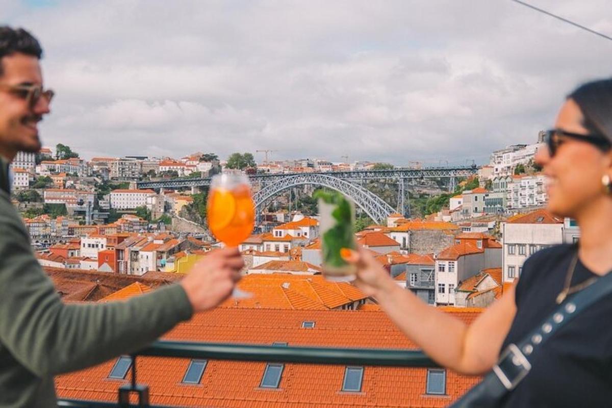 a man and woman holding up drinks in front of a city