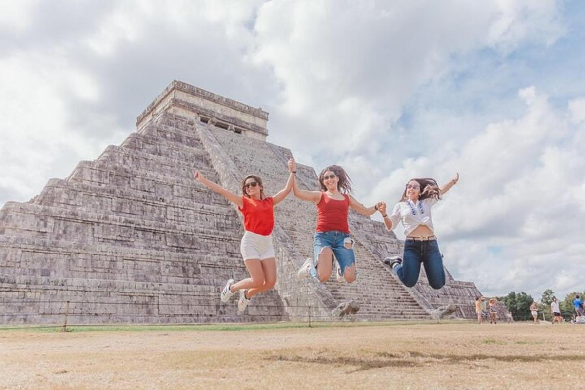 three girls jumping in front of a pyramid