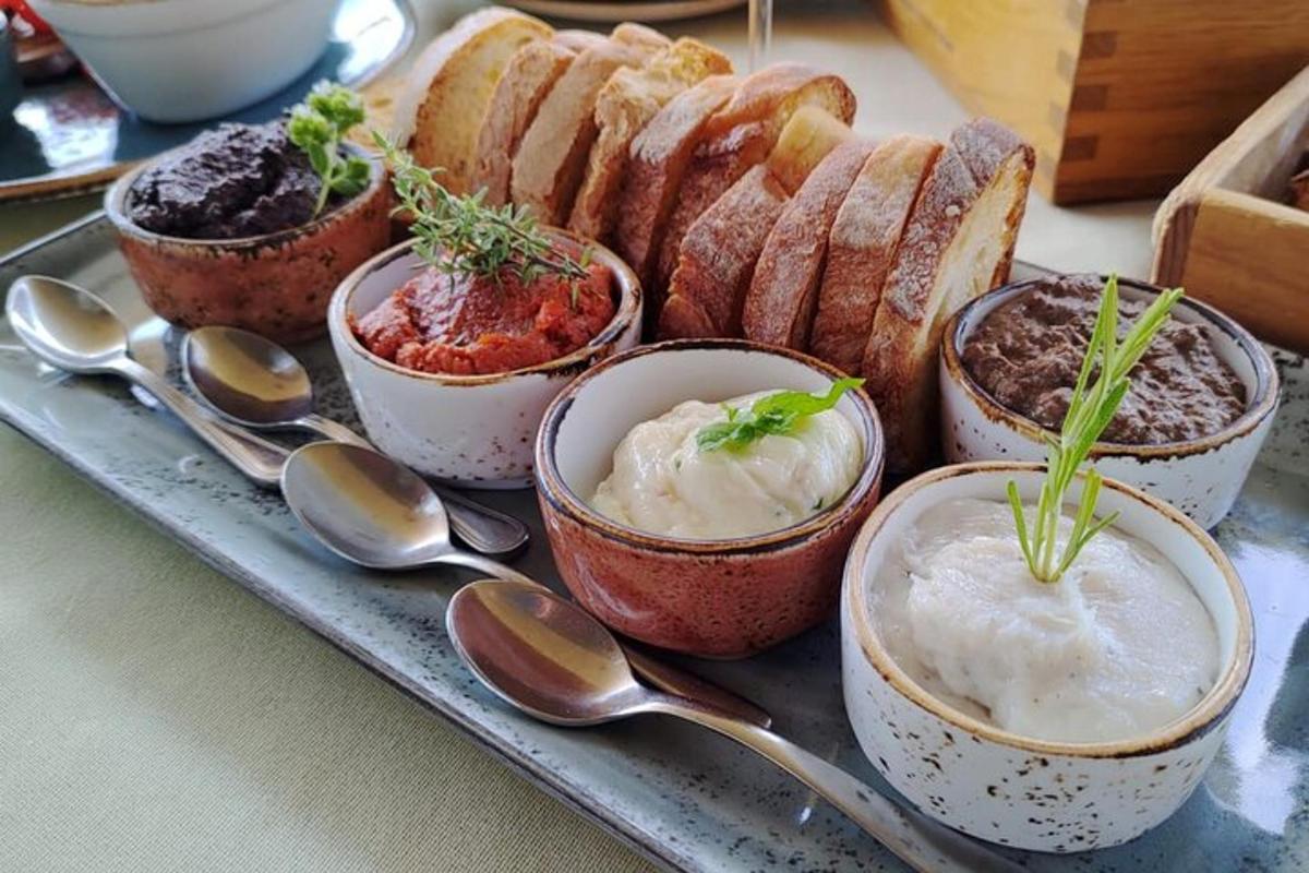 un vassoio con ciotole di salse, pane e cucchiai