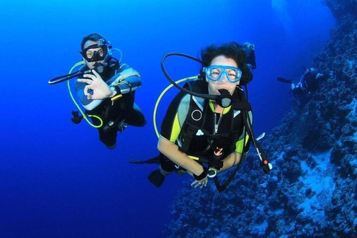 δύο άτομα κάνουν καταδύσεις στα γαλάζια νερά