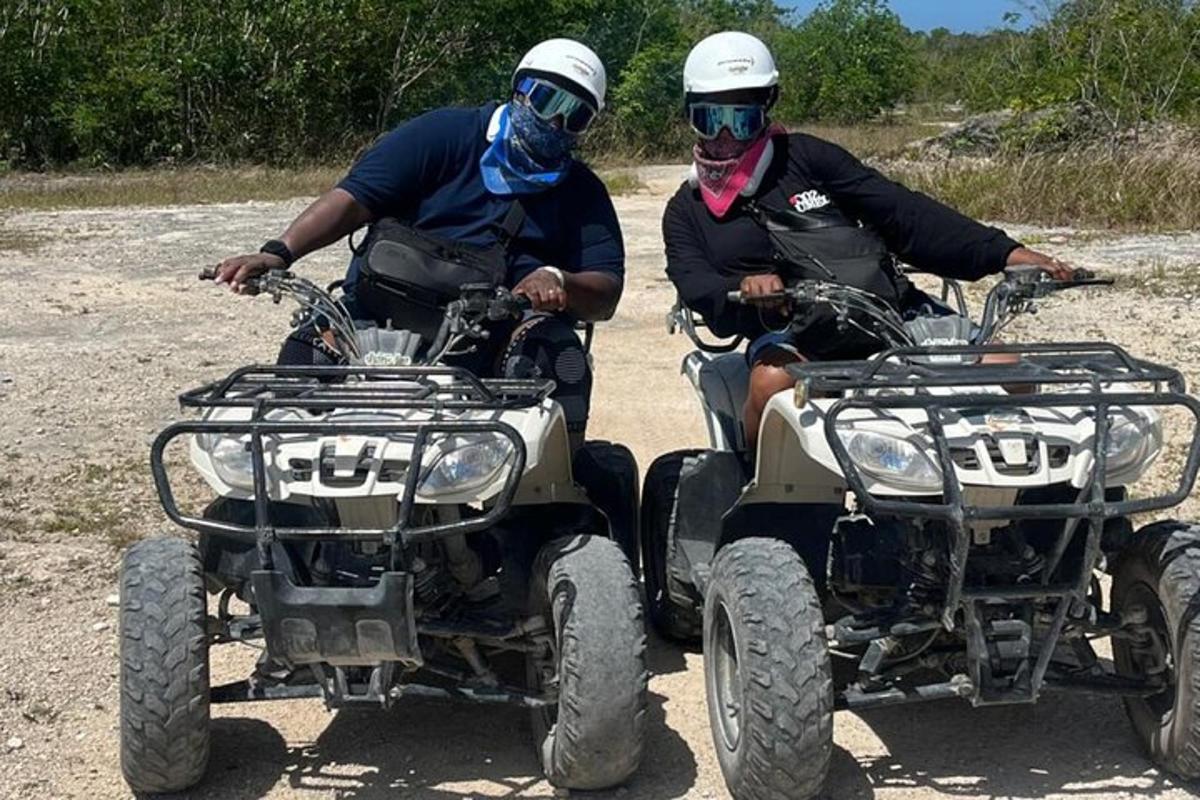 dues persones que viatgen en quads per un camí de terra