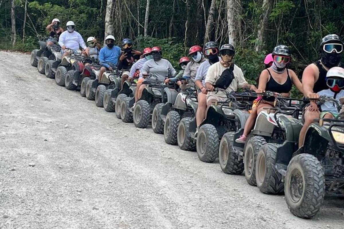 un grup de persones que condueixen quads per un camí de terra