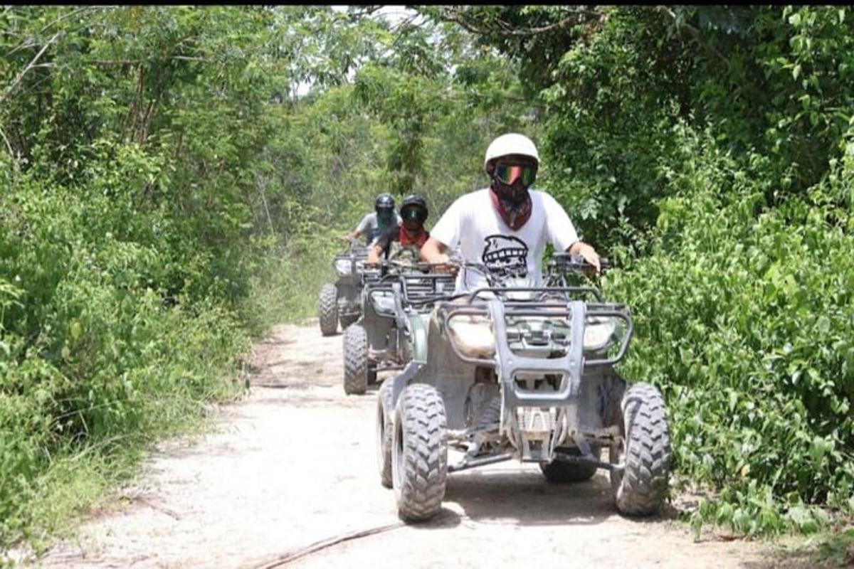 un uomo su un quad su una strada sterrata