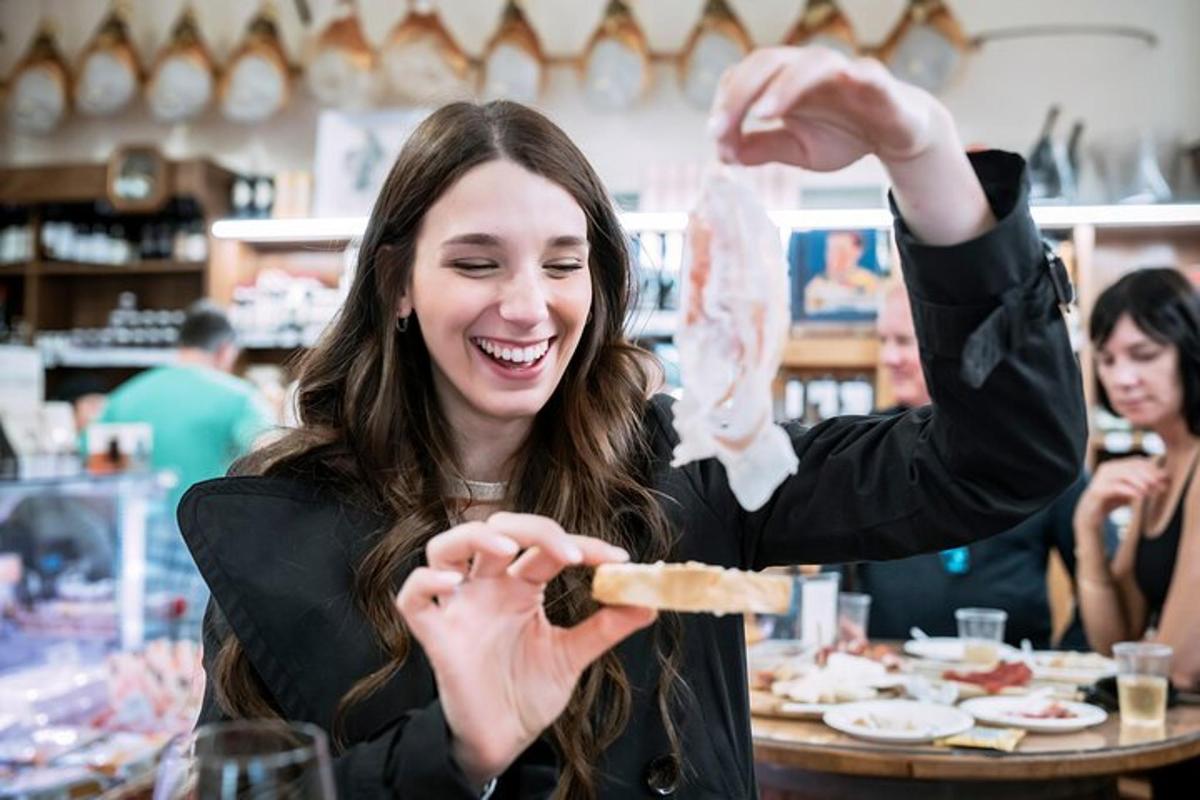 una donna sorride mentre tiene in mano un pezzo di cibo
