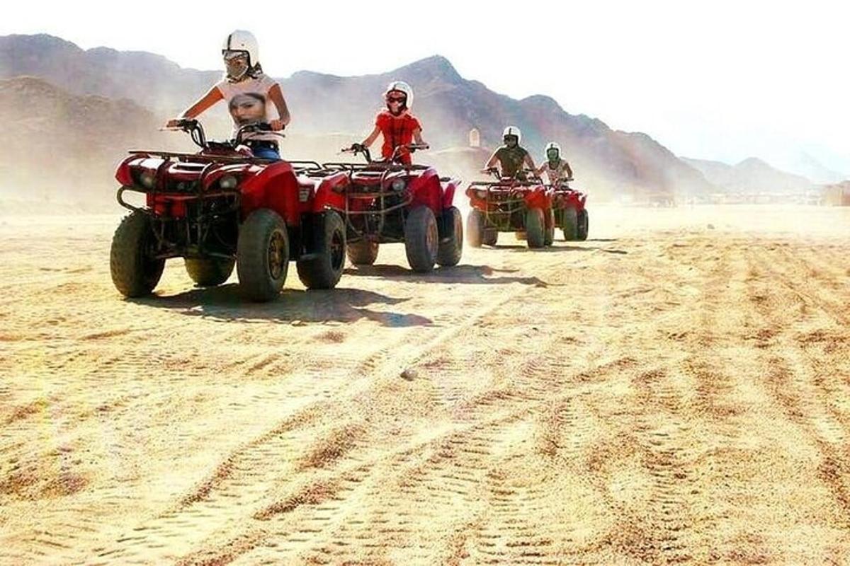un gruppo di persone in sella a quad nel deserto