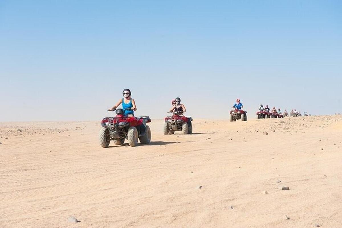 un gruppo di persone che guidano quad nel deserto