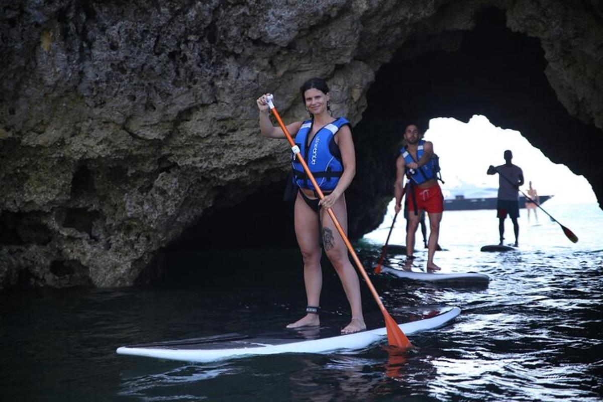 un grup de oameni pe plăci de paddle într-o peșteră