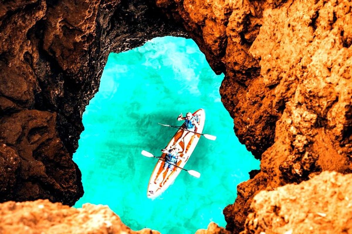một nhóm người chèo thuyền kayak trên mặt nước từ một hang động