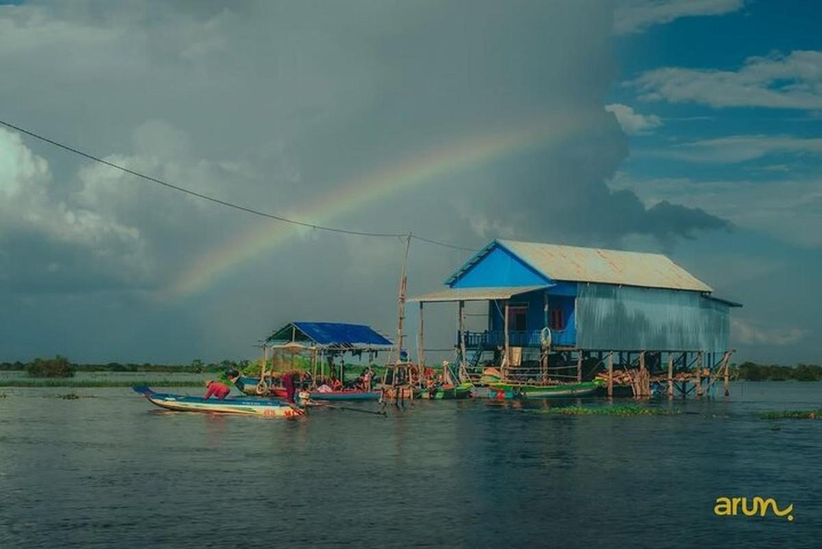 sekelompok perahu di air dengan pelangi di langit