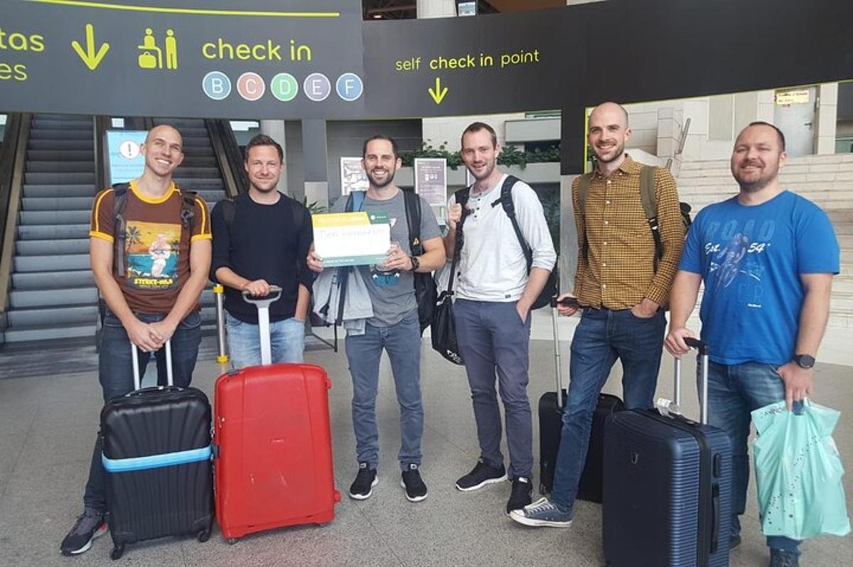 skupina mužů stojících se zavazadly na letišti