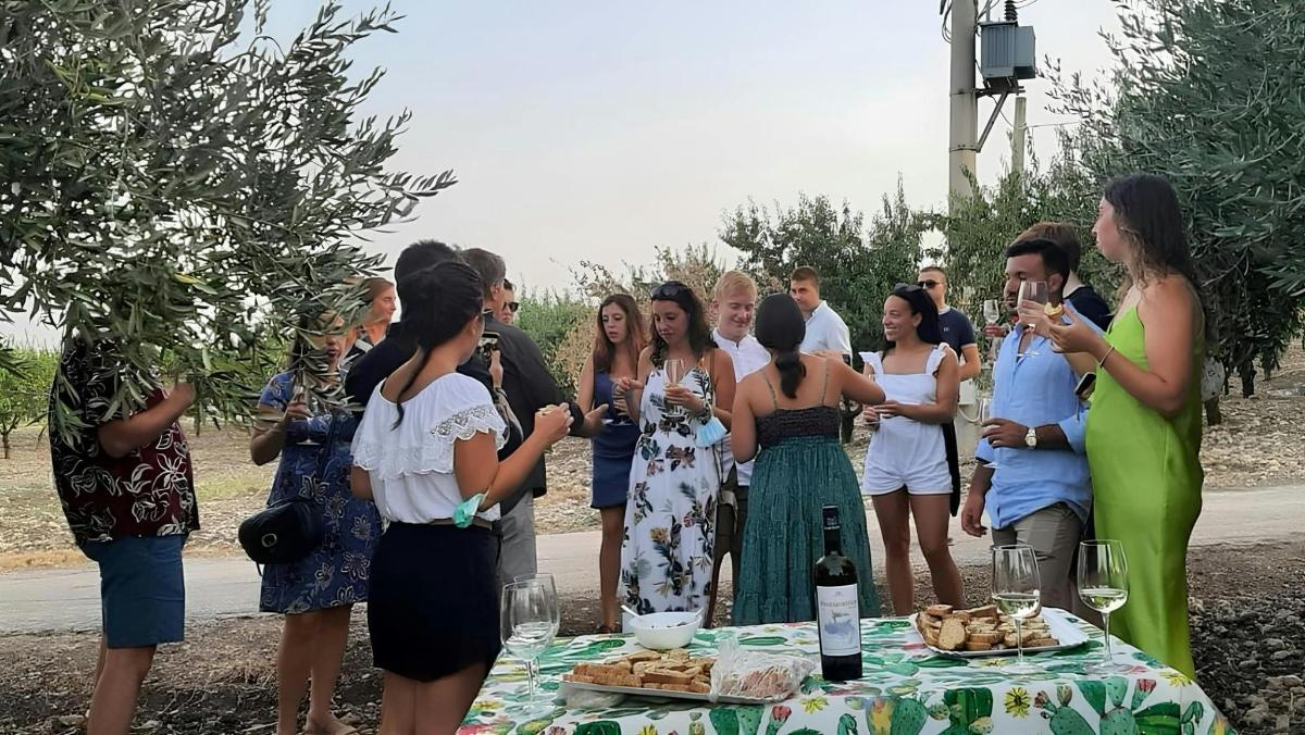 a group of people standing around a table with wine glasses