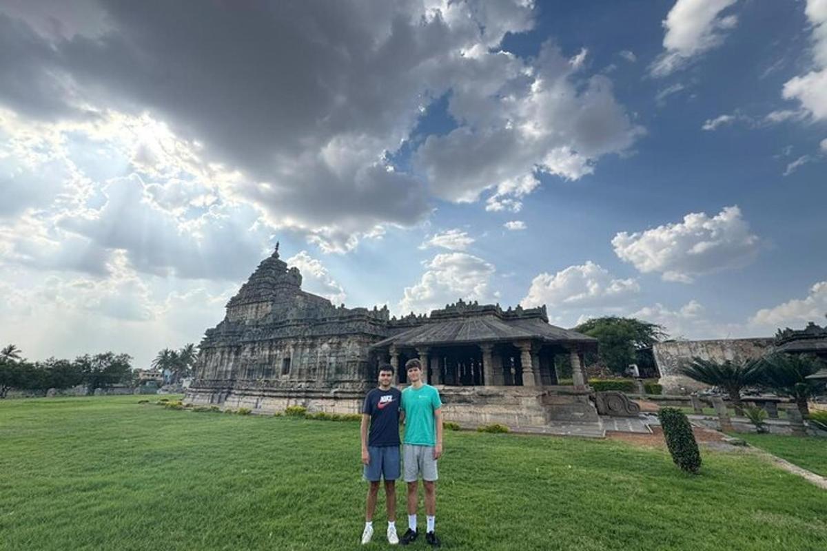 two men standing in a field in front of a building
