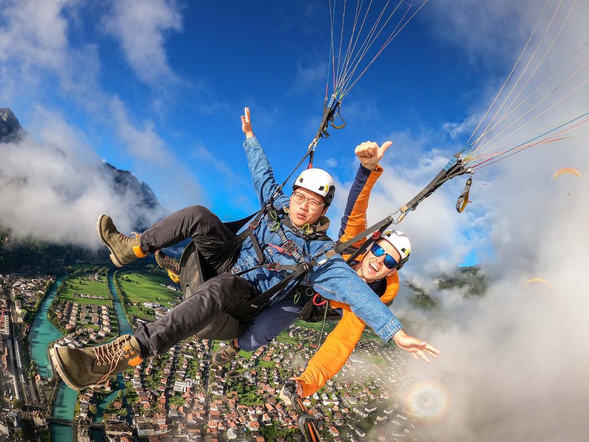 a group of people flying through the air on a parachute