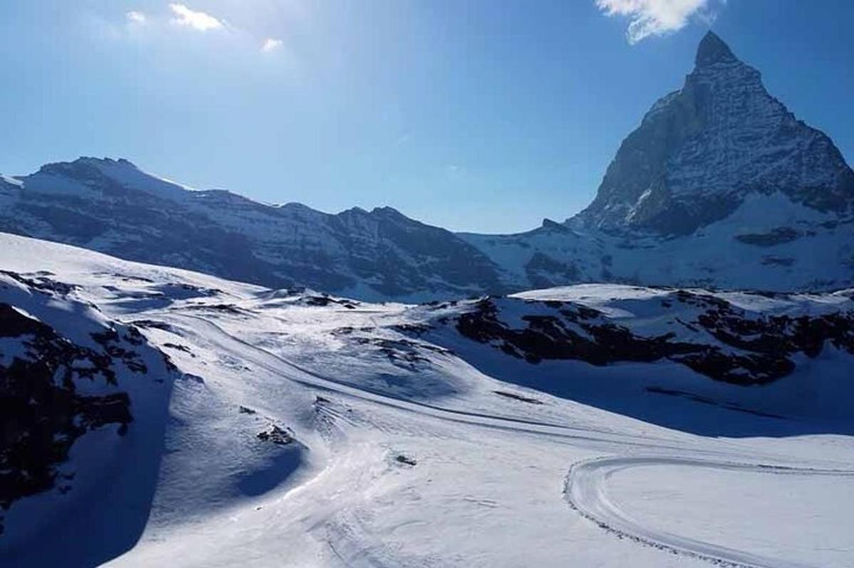 una montagna innevata con una strada in lontananza