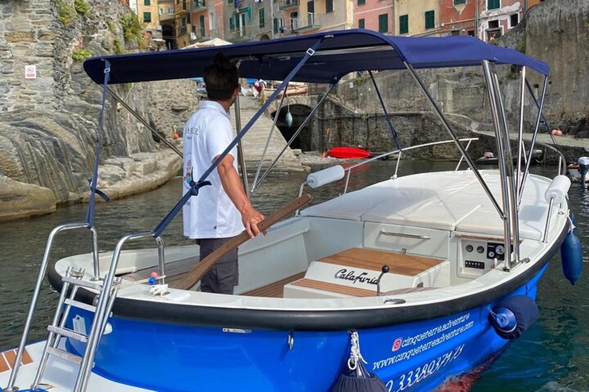 a man is standing on a blue and white boat
