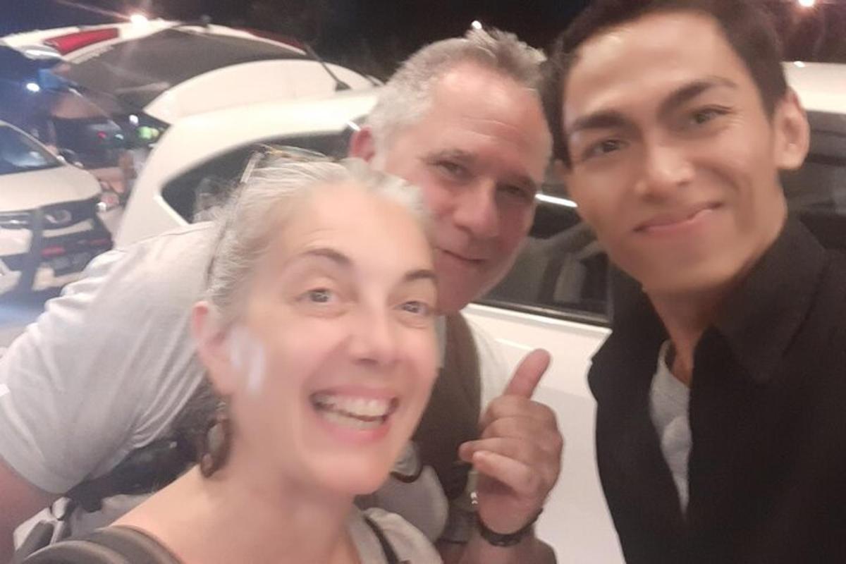 tre persone posano per una foto in macchina