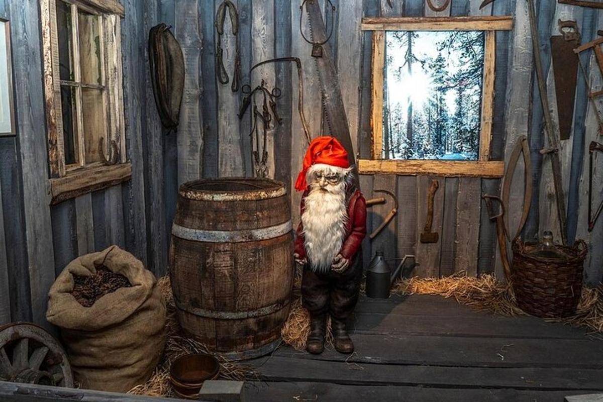 a cat dressed as a santa claus standing next to a barrel