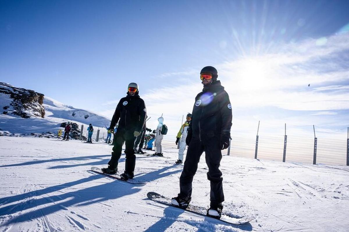 skupina lidí stojících na snowboardech ve sněhu