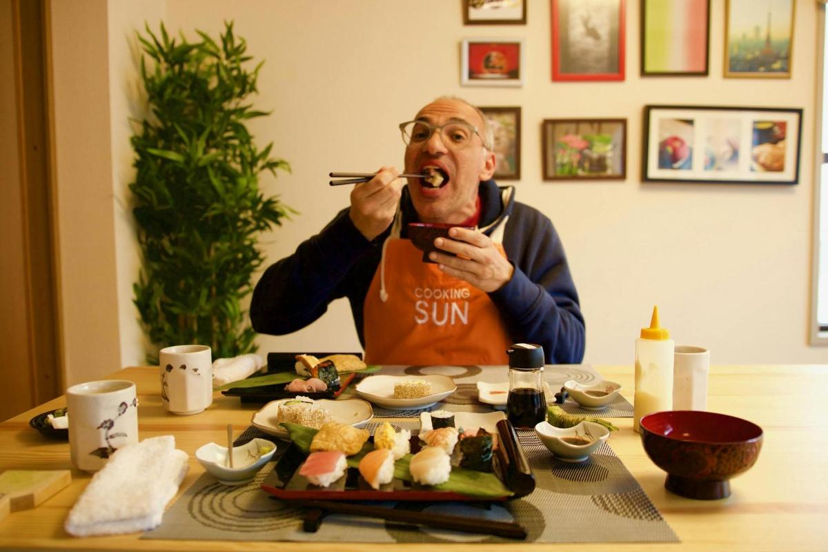 mees sööb söögipulk suus sushit