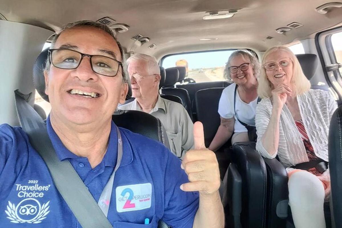 Skupina ljudi, ki sedijo v kombiju in kažejo palec gor