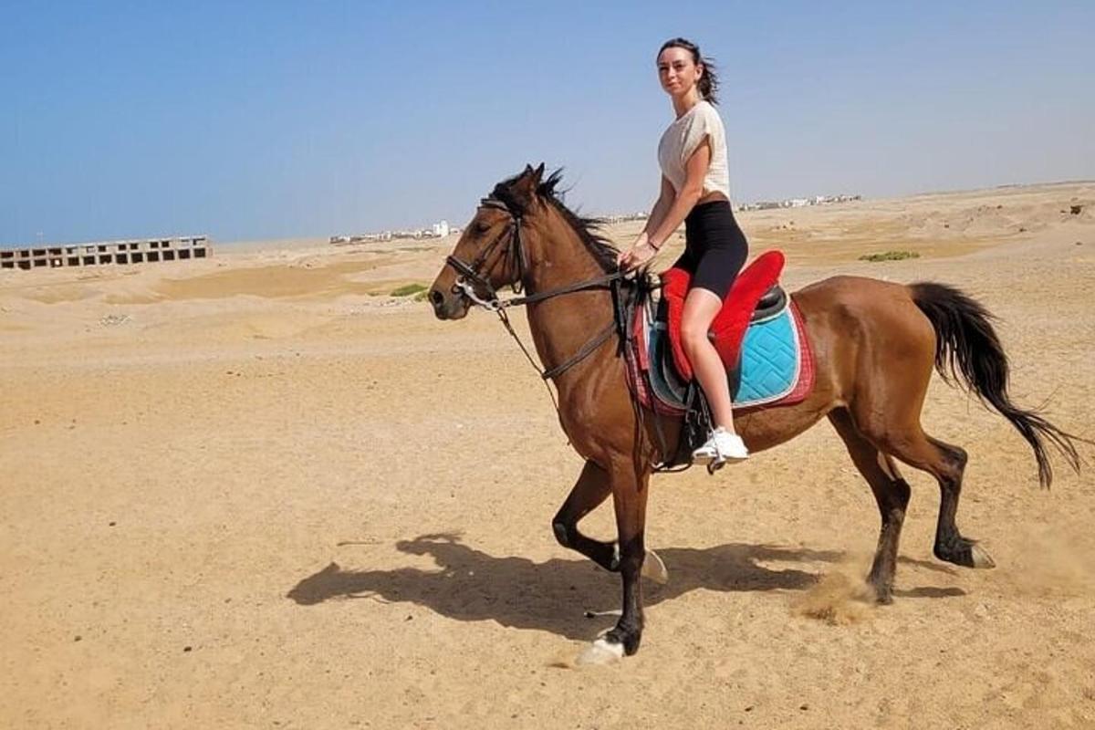 žena jedoucí na koni na pláži