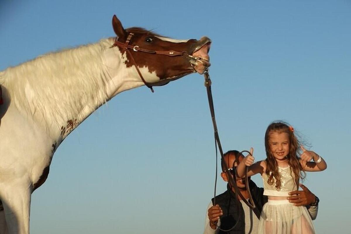 una ragazza in piedi accanto a un cavallo finto