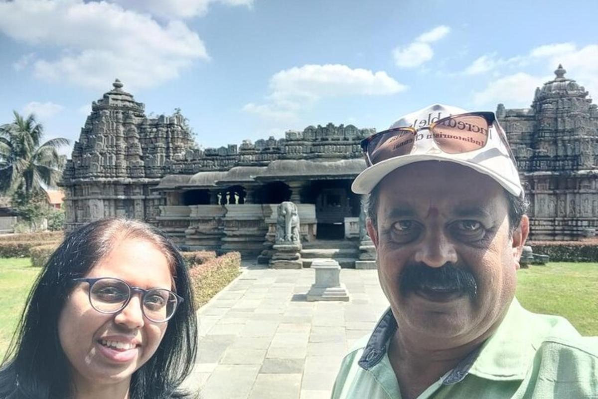 a man and a woman standing in front of a temple
