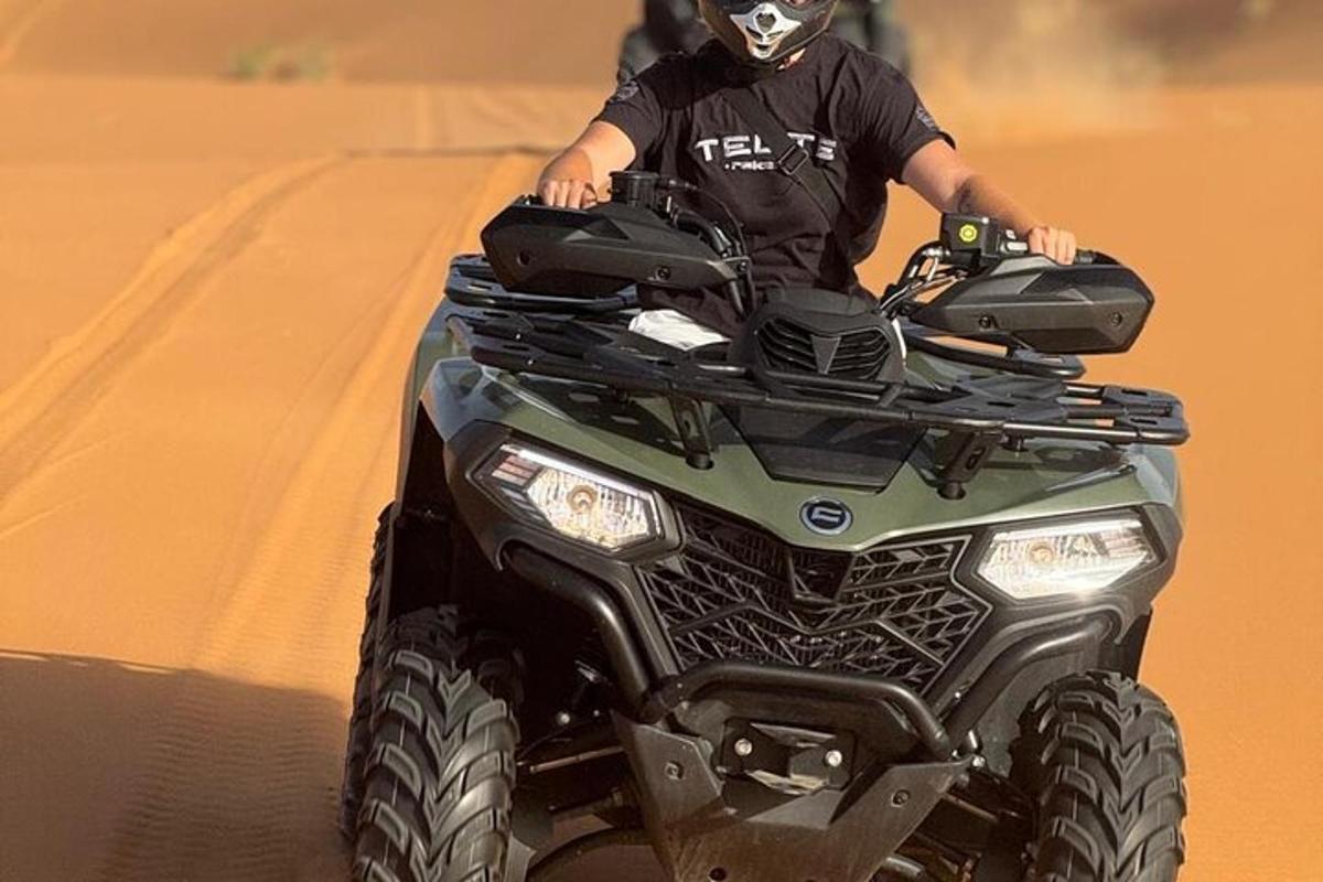 a man riding a quad bike in the desert