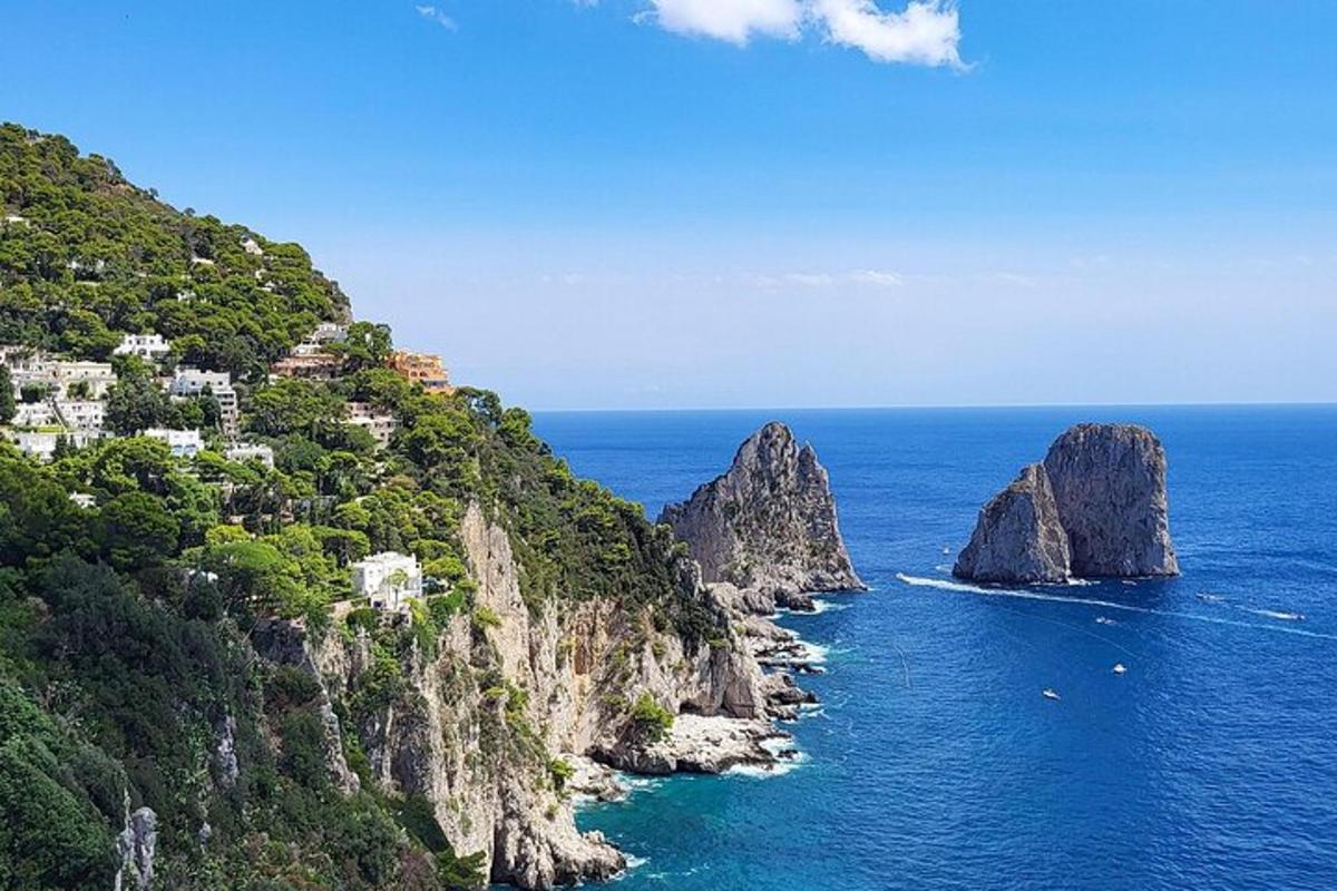 a view of the ocean with houses on a mountain