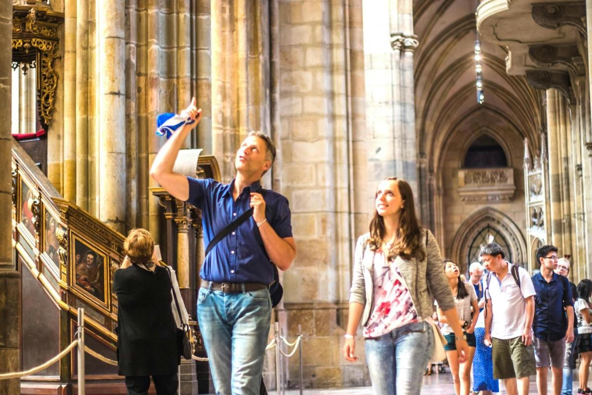 gent caminant per una catedral amb un home que sosté un micròfon