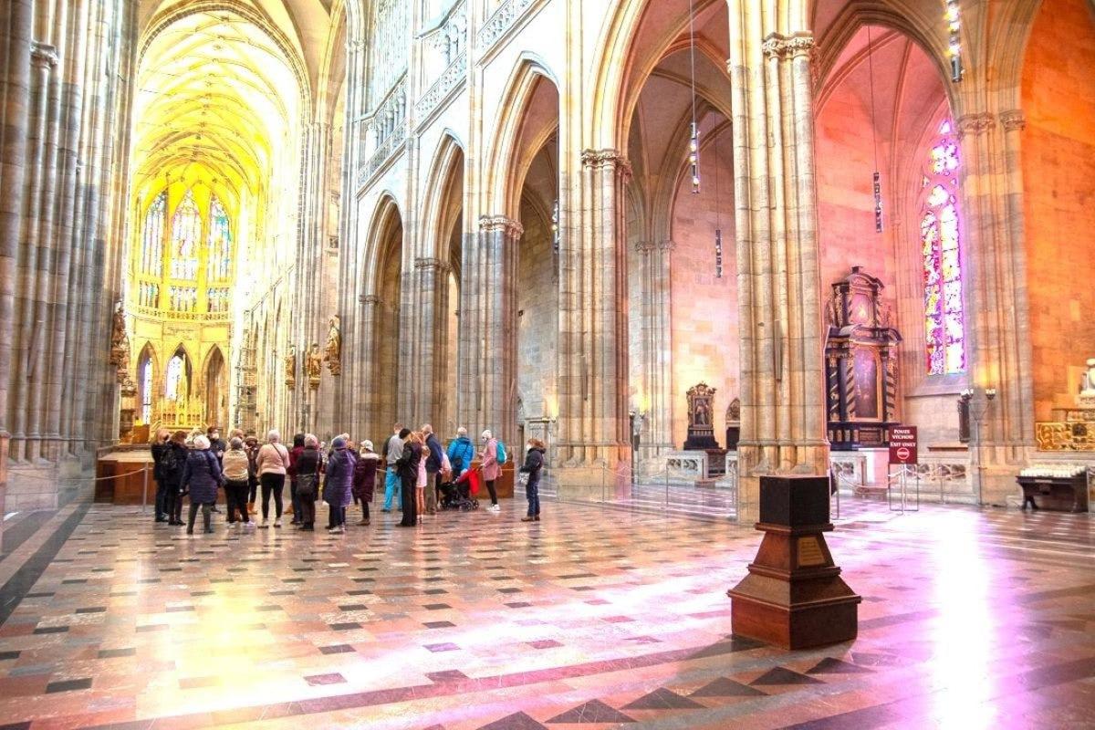 Un grupo de personas de pie en una gran catedral.