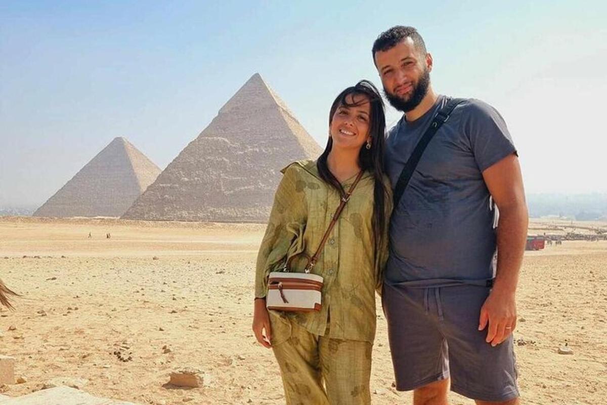 en mann og en kvinne som står foran pyramidene