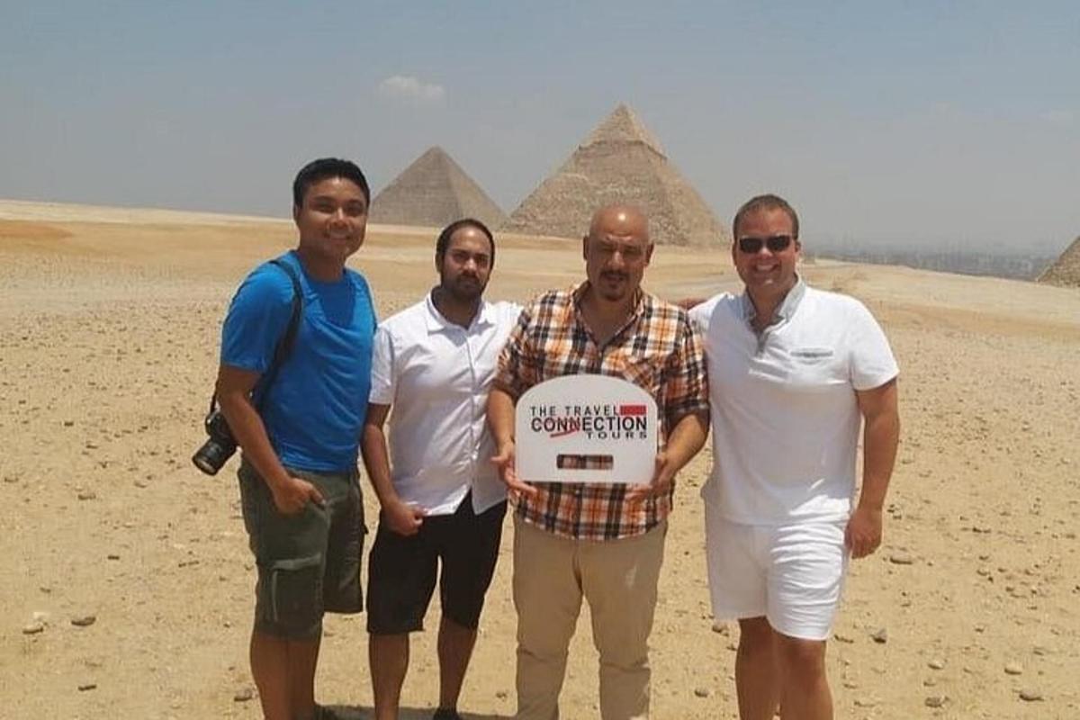 en gruppe menn som holder et skilt foran pyramider