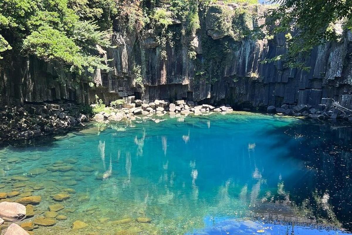 a pool of blue water with trees and rocks