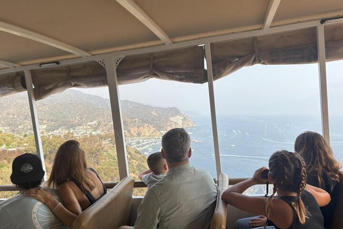 un grup de persones assegudes en un autobús mirant l'oceà