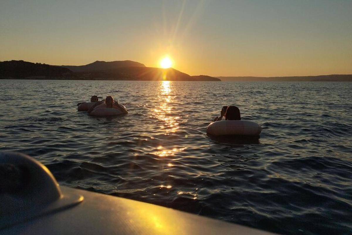Tres personas están en el agua al atardecer en flotadores.