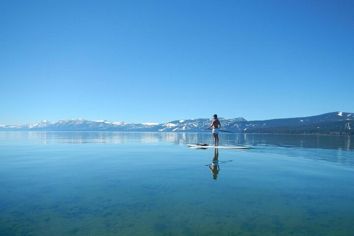 osoba stojící na paddleboardu ve vodě