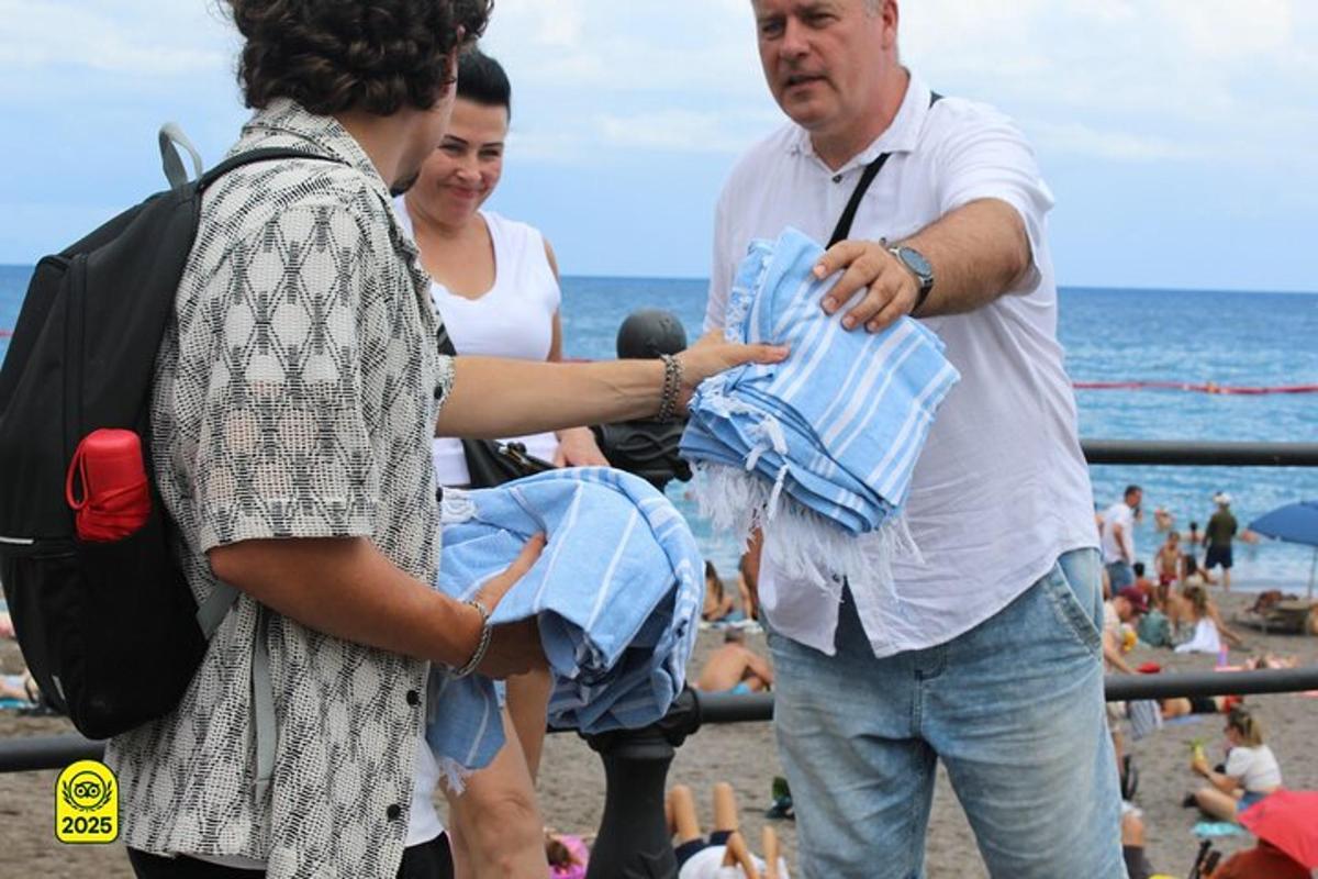 muž držící dítě se dvěma ženami na pláži