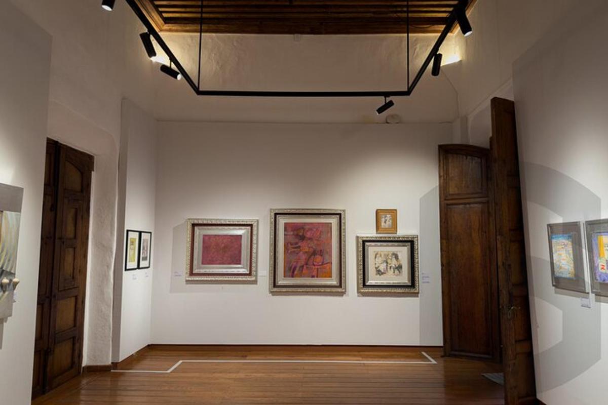 a room with paintings on the walls of a museum