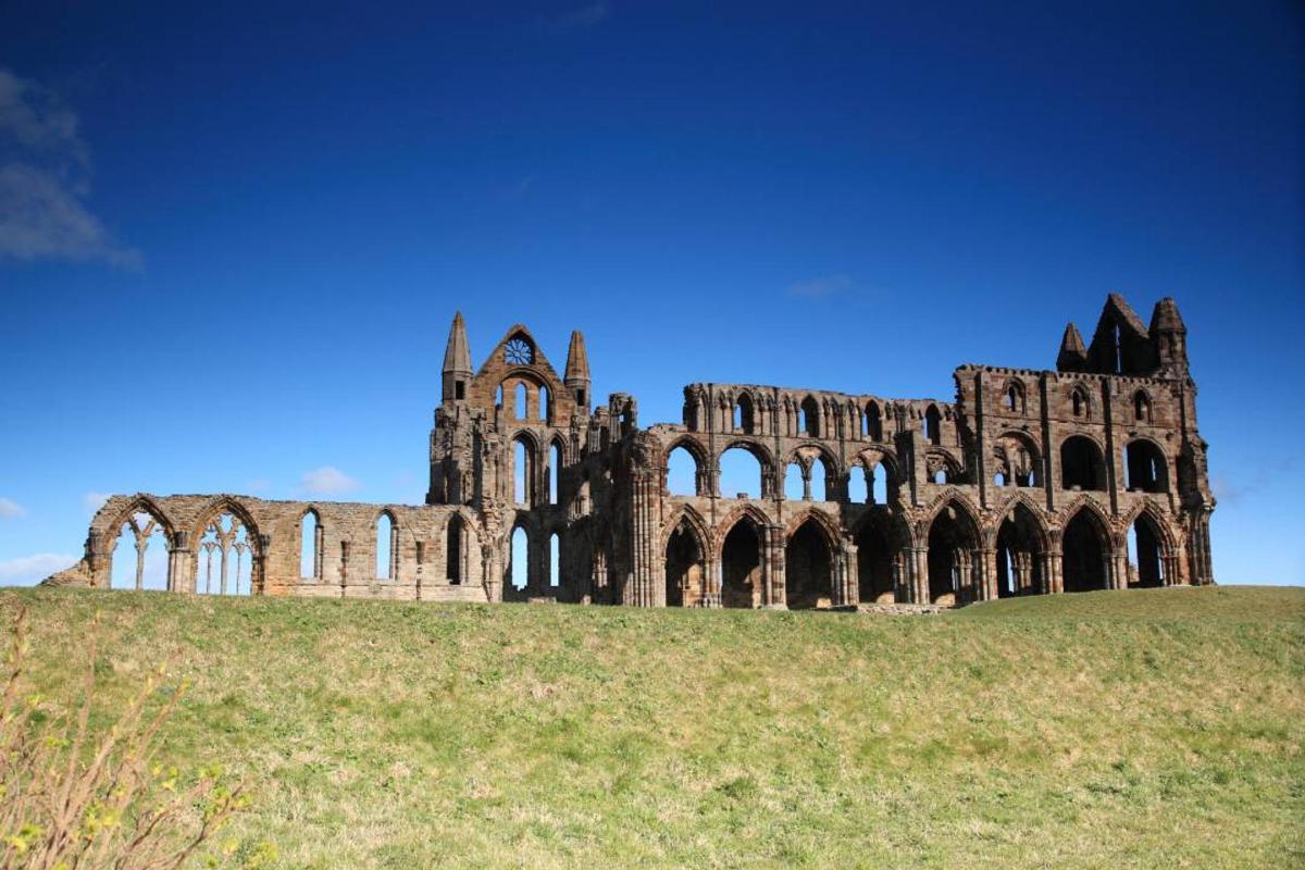an old building on top of a grassy hill