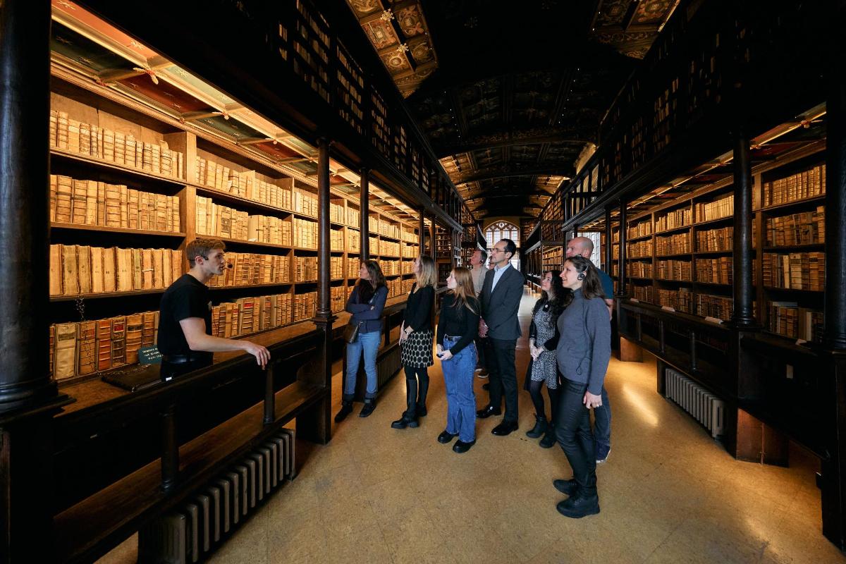eine Gruppe von Menschen steht in einer Bibliothek
