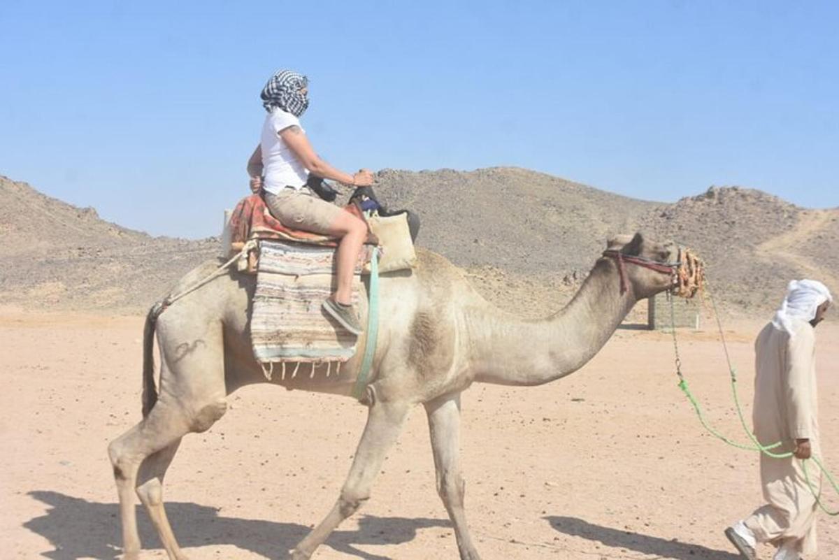 een vrouw die op de rug van een kameel rijdt