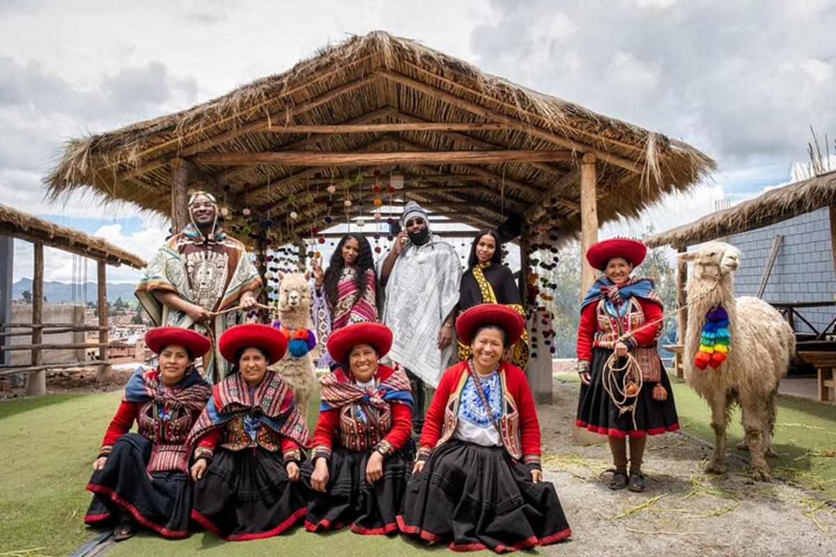 Un grupo de personas con trajes tradicionales frente a una choza.