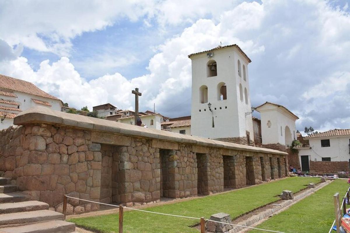 un edificio con una torre de reloj en lo alto de un muro de piedra