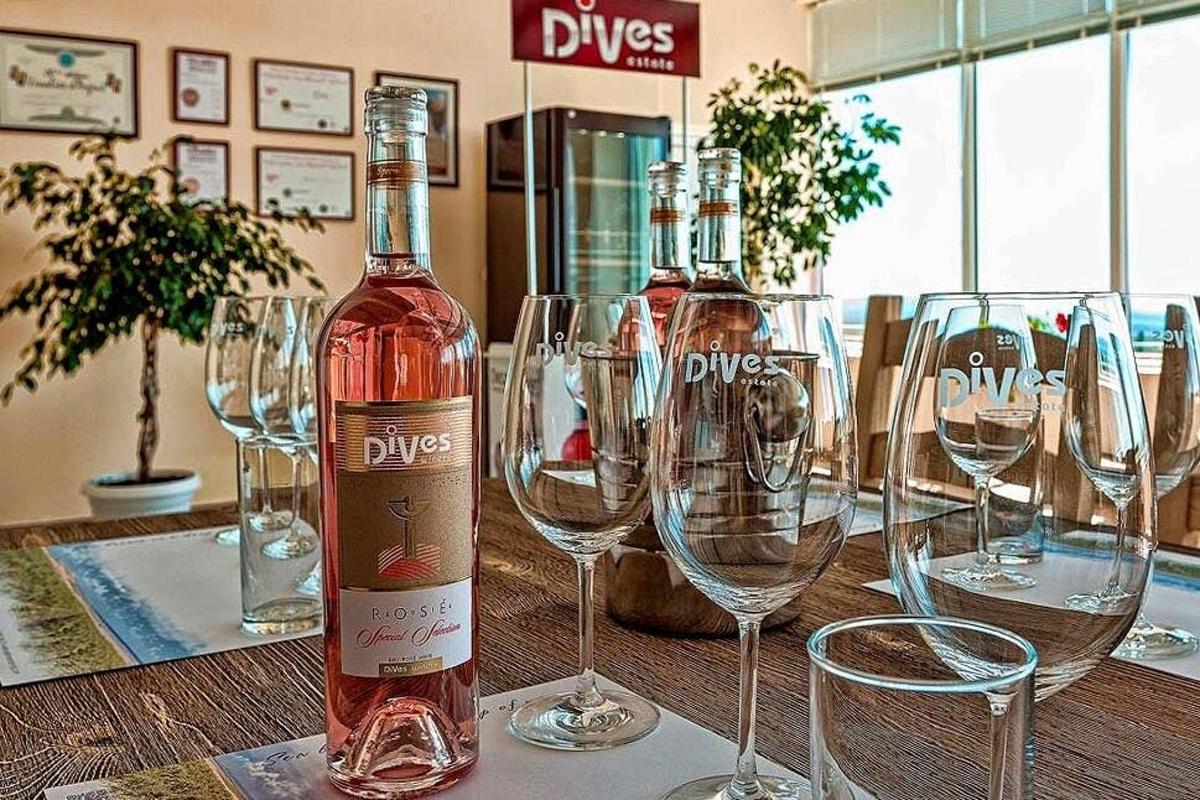 a bottle of wine sitting on a table with wine glasses